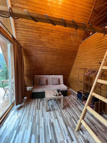 a room with a bed and a table in a cabin at Cabane A-Frame Svinița in Sviniţa