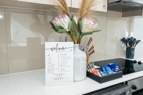 a kitchen counter with a menu and flowers in a vase at Azure 213-Luxury 2 Bedroom Apartment with an Inverter & Battery Backup Power in Big Bay