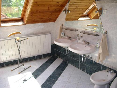 La salle de bains est pourvue de 2 lavabos et de toilettes. dans l'établissement Anonim Vendégház, à Villány