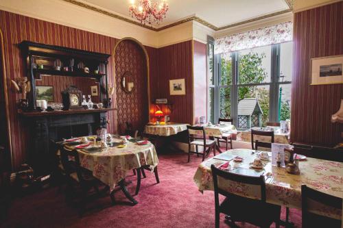 a dining room with tables and chairs and a window at Penrose Bed & Breakfast in Lostwithiel