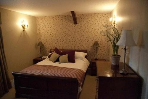 a bedroom with a bed and a table and lamps at The Lion in Leintwardine