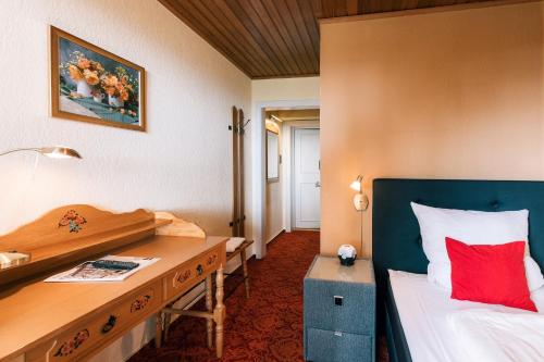 Schlafzimmer mit einem Schreibtisch, einem Bett und einem Schreibtisch in der Unterkunft Hotel Hasenjäger in Einbeck