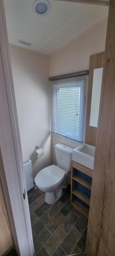 a bathroom with a toilet and a tub and a sink at Tattershall lakes breaks Swan view in Tattershall