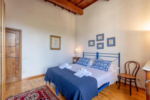 Un dormitorio con una cama azul y blanca y una silla en Discovering Florence en Florencia