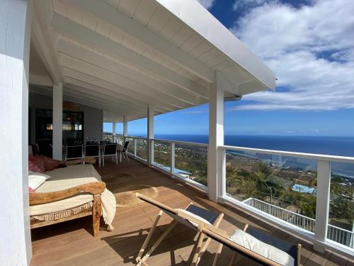 a bedroom with a balcony with a view of the ocean at Le Belvédère - Meublé 4 étoiles in Saint-Leu