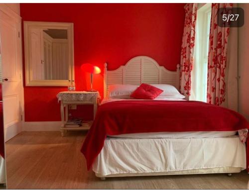 a red bedroom with a bed with a red wall at Redgate House Bed & Breakfast in Derry Londonderry