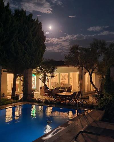 a house with a swimming pool at night at Bir Dem Urla in Urla