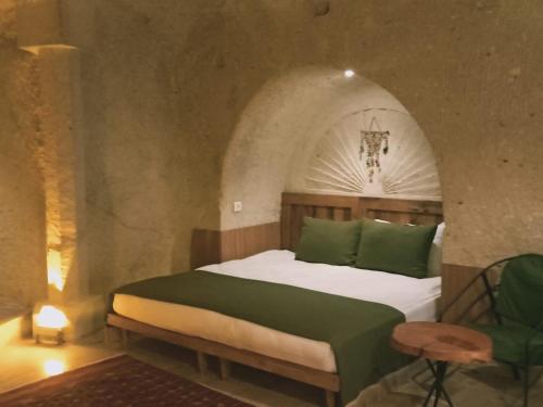 a bedroom with a bed in an arched room at Vigneron Cave Hotel in Nevsehir