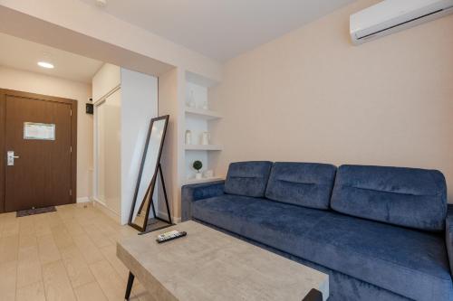 a blue couch in a living room with a table at The SPOT apartments - Orbi Beach Tower in Batumi