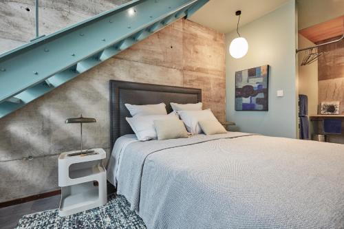 1 dormitorio con 1 cama grande y una escalera en LA PORTE ROUGE RBX, en Roubaix