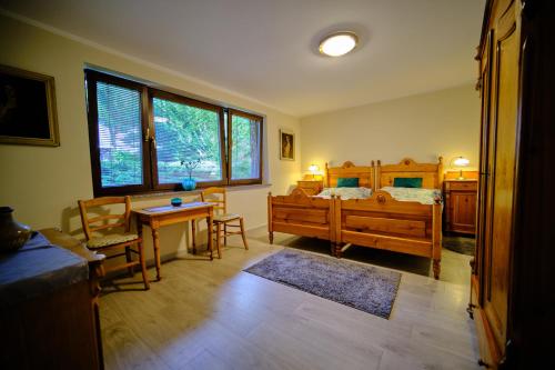 een slaapkamer met een bed en een tafel en stoelen bij Apartament Przy Beczce in Kowary