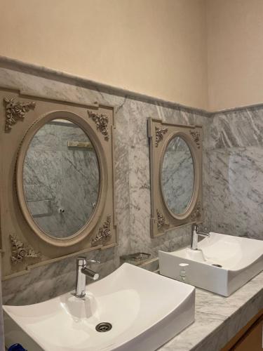 uma casa de banho com dois lavatórios e dois espelhos em Villa DAAD OURIDA piscine chauffée em Marraquexe