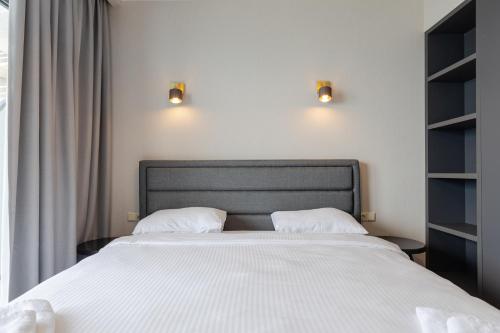 a bedroom with a large white bed with two pillows at The SPOT apartments - Orbi Beach Tower in Batumi