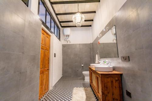a bathroom with a sink and a toilet and a mirror at Seclude Shimla, Taraview in Shimla