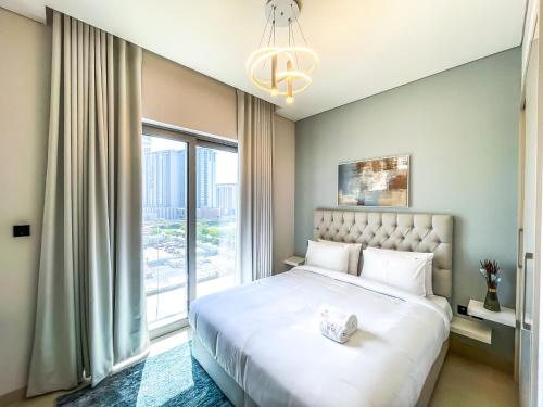 een slaapkamer met een groot bed en een groot raam bij STAY BY LATINEM 2BR Holiday Home CV B514 near Burj Khalifa in Dubai