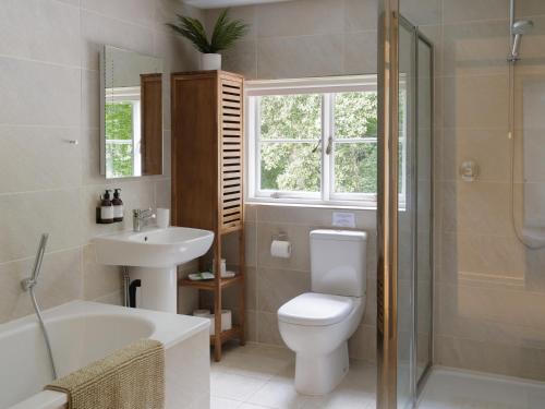 y baño con aseo, lavabo y ducha. en The Walled Garden at Woodhall Estate en Hertford