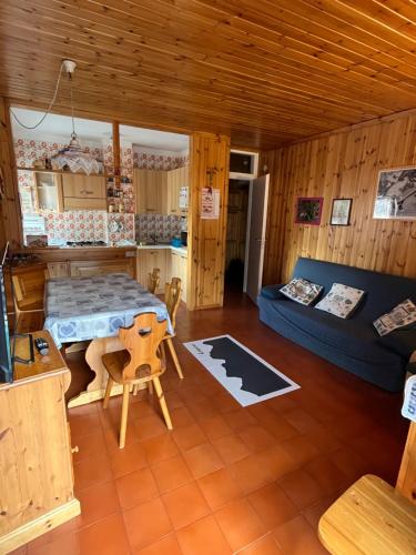 Cette chambre comprend un lit, une table et un canapé. dans l'établissement Casa Lulu', à Predazzo