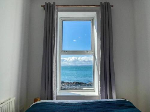 a window in a bedroom with a view of the ocean at The Cranny, Portstewart in Portstewart
