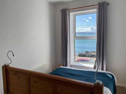 a bedroom with a window with a view of the ocean at The Cranny, Portstewart in Portstewart