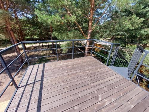 a wooden walkway with a fence and trees at Domek - Carineczka Chańcza in Chańcza