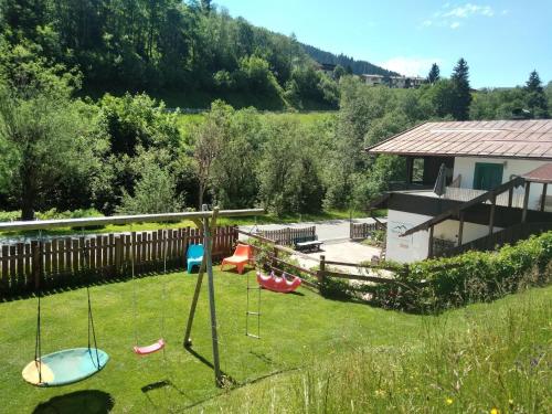 a yard with swings in the grass with a house at Apartment in Dienten near Gabühel Ski Lift in Dienten am Hochkönig