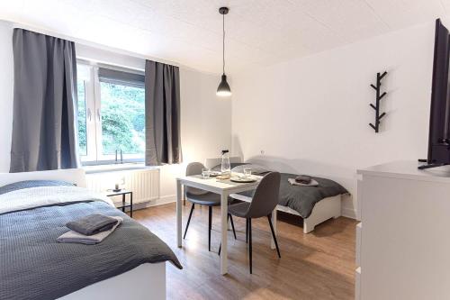 a bedroom with a bed and a table with chairs at Modern Apartment in Lüdenscheid in Lüdenscheid