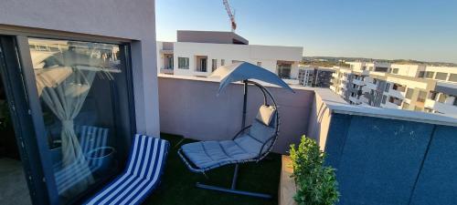 a balcony with a blue chair and an umbrella at Jacuzzi Home in Oradea