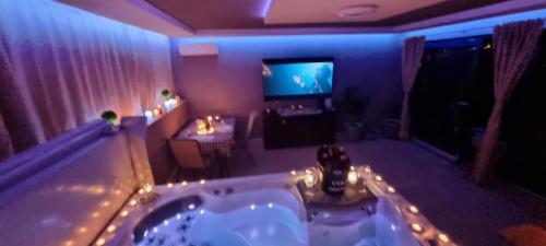 a bathroom with a tub with a tv in it at Jacuzzi Home in Oradea