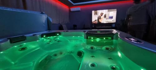 a green bath tub in a room with a tv at Jacuzzi Home in Oradea