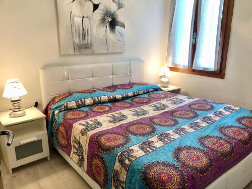 a bedroom with a bed and two tables with lamps at Paradise Apartment Malcesine in Malcesine