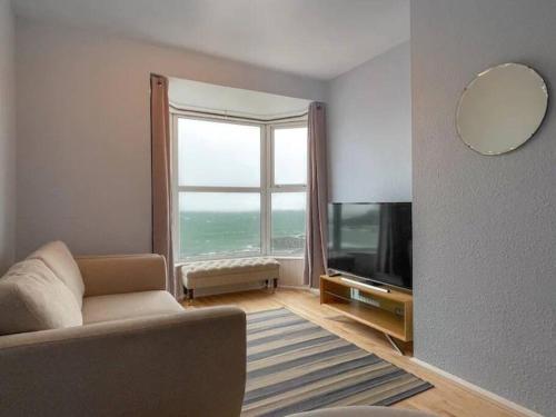 een woonkamer met een bank en een groot raam bij The Nook, Portstewart in Portstewart