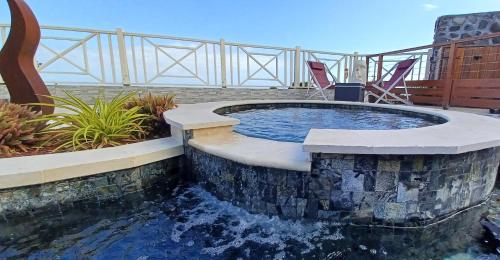 a small pool with a spa in a patio with chairs at Bourbon Horizon in La Possession