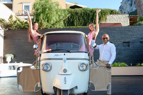 a man and two women standing next to an old car at Villa Marina Capri in Capri