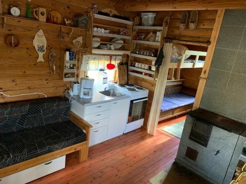 a kitchen with a stove and a sink in a cabin at Kesämökki Kalliola Heinola in Ahvenisto