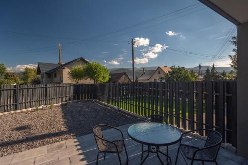 a patio with a table and chairs and a fence at Apartament Widok in Piechowice