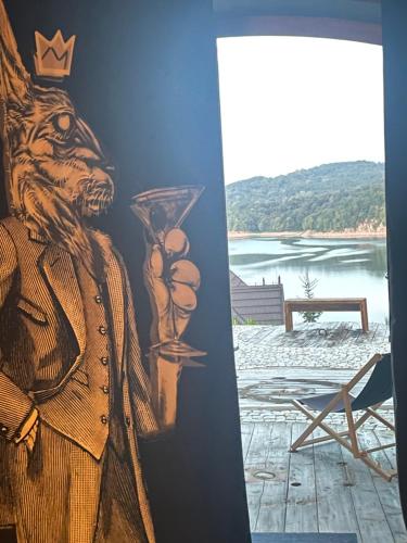 a painting of a bear on a wall next to a chair at Ostoja Spokoju in Olchowiec