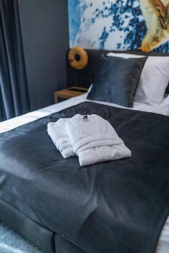 a white robe sitting on top of a bed at 4 Évszak Erdeihotel**** - Mátrafüred in Mátrafüred