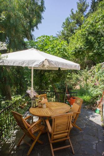 a wooden table and chairs with an umbrella at Valeondades in Valeontádes
