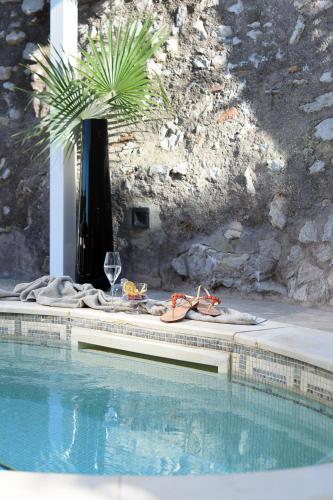 a pair of shoes and a glass of wine next to a swimming pool at Villa Marina Capri in Capri