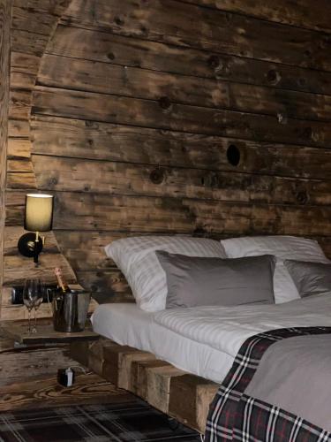 a bedroom with a wooden wall with a bed at Ostoja Spokoju in Olchowiec