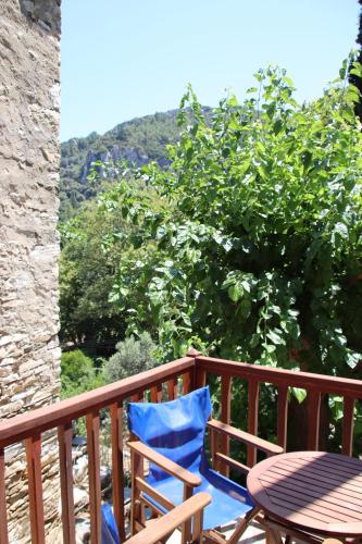 a wooden deck with a table and a blue chair at Valeondades in Valeontádes