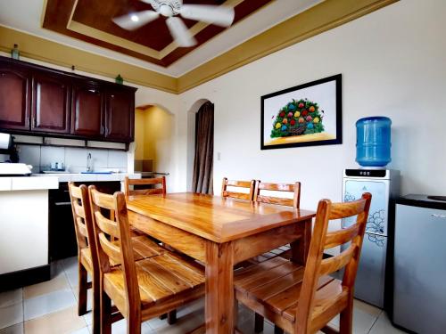 a dining room with a wooden table and chairs at Den Den Guesthouse in Basco