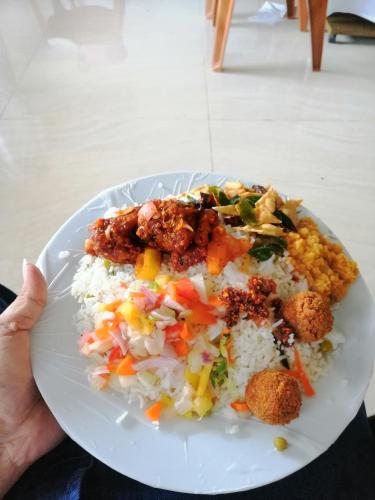 a plate of food with rice and vegetables on it at Udara's Colombo Rooms in Battaramulla