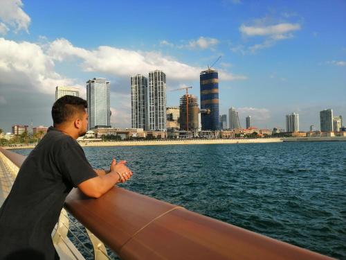 a man standing on a boat looking at the city at Udara's Colombo Rooms in Battaramulla