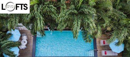 an overhead view of a swimming pool with trees overhead at BYD Lofts - Boutique Hotel & Serviced Apartments - SHA Extra Plus in Patong Beach