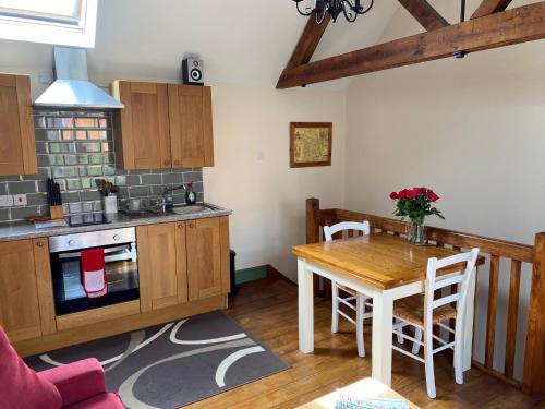 a kitchen and dining room with a table and a stove at Stable Cottage, Bishops Castle in Bishops Castle