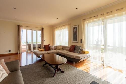 a living room with a couch and a table at Bellevue Villa Madeira Magnificent Sea View in Prazeres