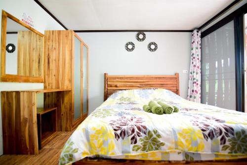 a bedroom with a bed with two stuffed animals on it at One khaokho homestay in Khao Kho