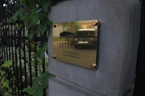 a sign on a wall with a reflection of a car at Villa Lettonia in Jūrmala