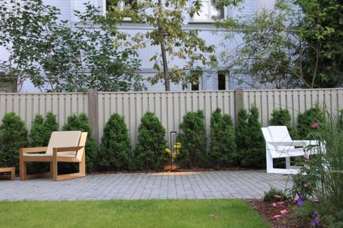 a backyard with two chairs and a fence at Villa Lettonia in Jūrmala